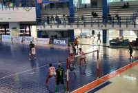 Pemain futsal Pamekasan (jersey merah putih) saat mencoba merebut bola dari pemain futsal Ponorogo (jersey hijau kuning) di Stadion Graha Polinema, Kota Malang, Minggu (22/6/2025).